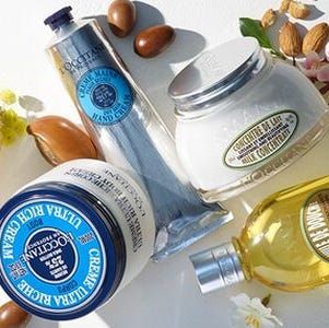 yellow, silver, blue and white l'occitane face and body skincare products on a white background with flowers and nuts