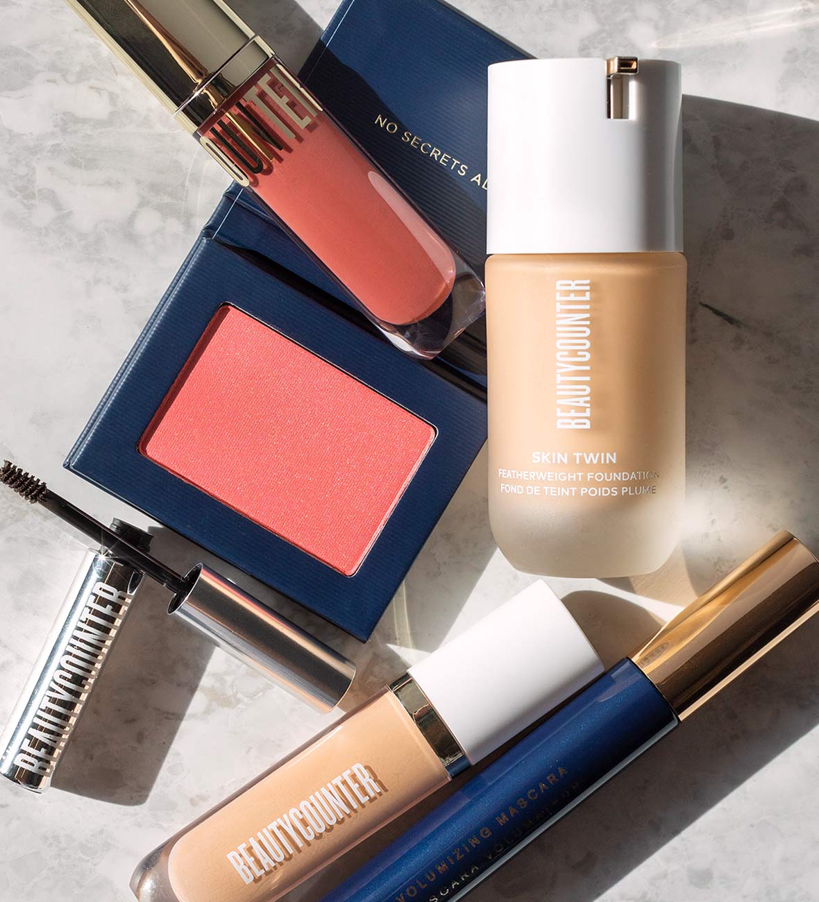 beautycounter makeup products on a gray marble background, one of the best clean beauty brands