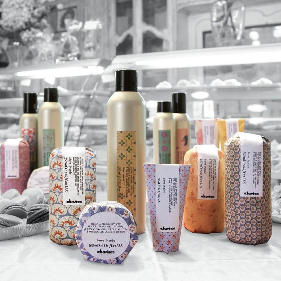 multi colored and patterned davines haircare and styling products on a black and white background